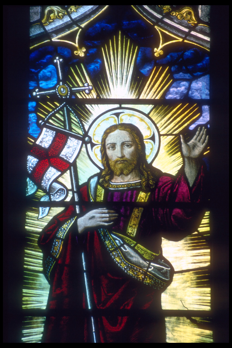 Jesus Christ supporting an English flag and staff in the crook of his right arm depicted in a stained glass window in <a href="/content/Rochester_Cathedral" style="color:blue">Rochester Cathedral</a>, Kent