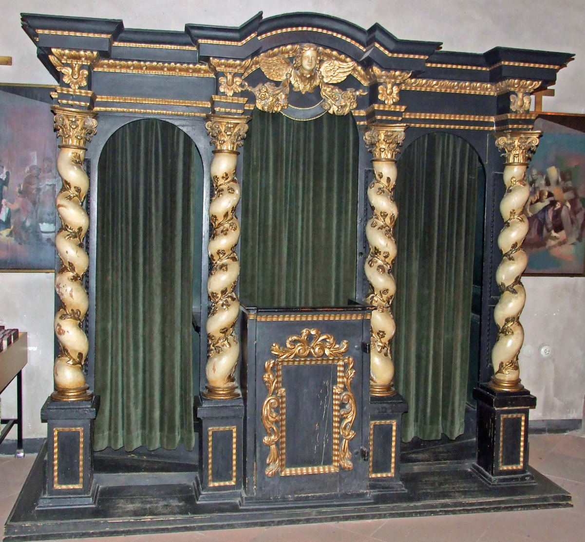In Roman Catholic settings, the traditional style of <a href="/content/Confessional" style="color:blue">confessional</a> allows the priest, seated in the center, to hear from penitents on alternating sides.
