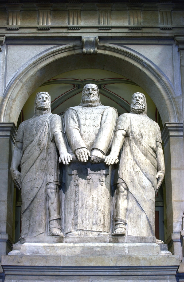 The Three Confederates (1914), monumental statue by <a href="/content/James_Vibert" style="color:blue">James Vibert</a> in the <a href="/content/Federal_Palace_of_Switzerland" style="color:blue">Federal Palace of Switzerland</a>.