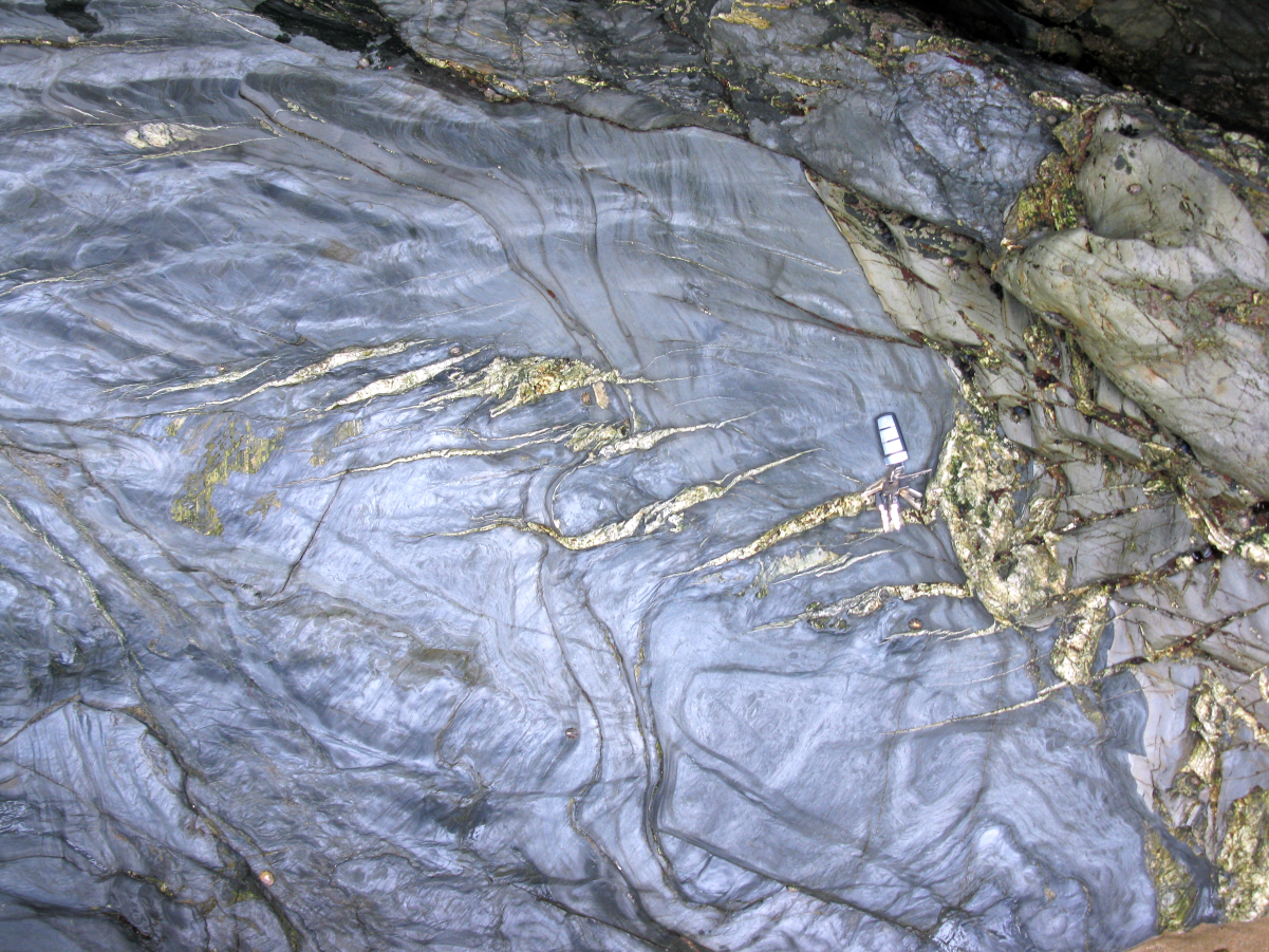 Left-lateral en échelon tension gash fractures in pelitic strata near <a href="/content/Newquay" style="color:blue">Newquay</a>, <a href="/content/Cornwall" style="color:blue">Cornwall</a>, <a href="/content/United_Kingdom" style="color:blue">U.K.</a> (Car key is approximately 7.5 cm long)