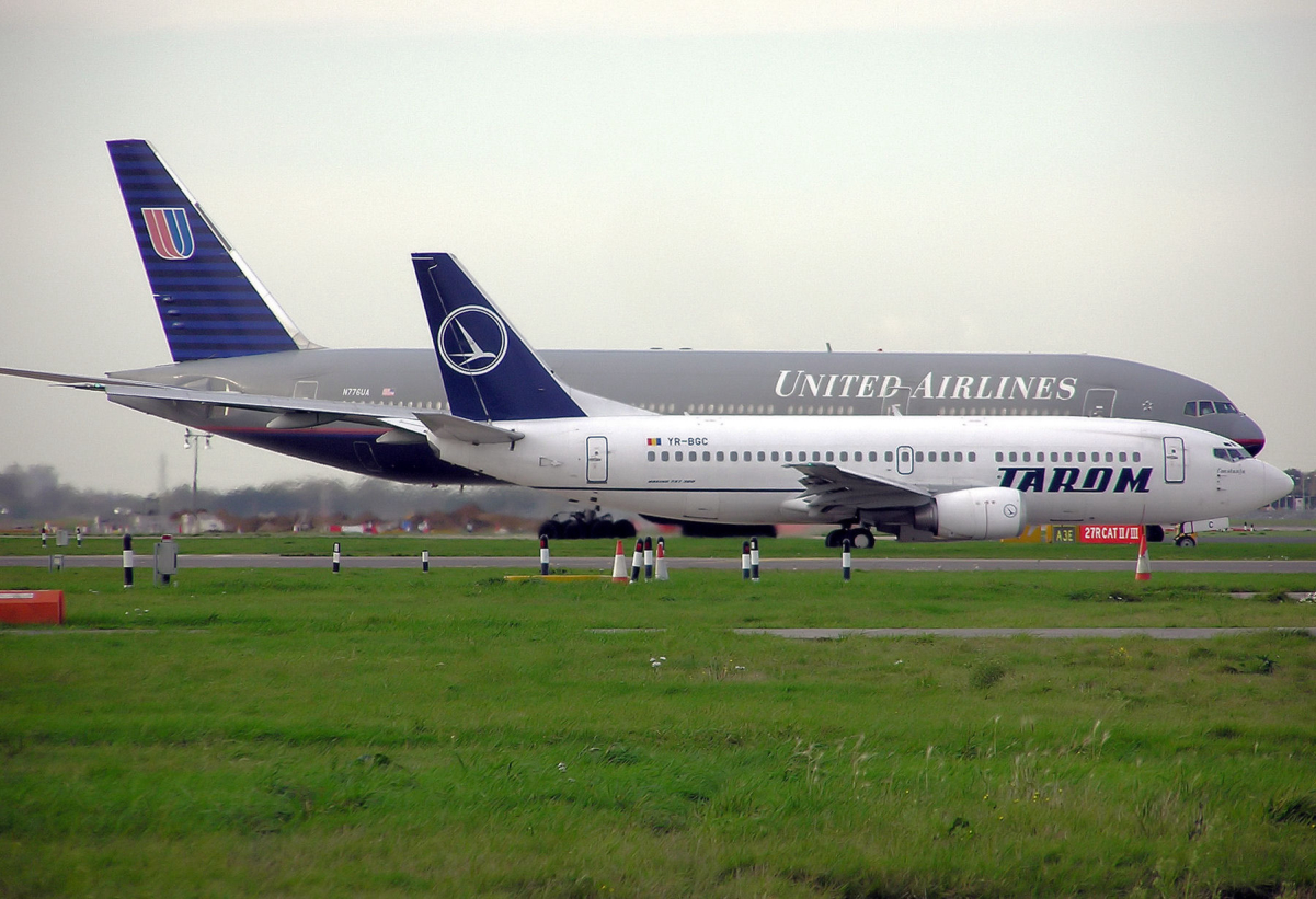 A <a href="/content/Tarom" style="color:blue">Tarom</a> <a href="/content/Boeing_737_Classic" style="color:blue">Boeing 737–300</a> and <a href="/content/United_Airlines" style="color:blue">United Airlines</a> <a href="/content/Boeing_777" style="color:blue">Boeing 777–200</a> taxiing to depart <a href="/content/London_Heathrow_Airport" style="color:blue">London Heathrow Airport</a>.
