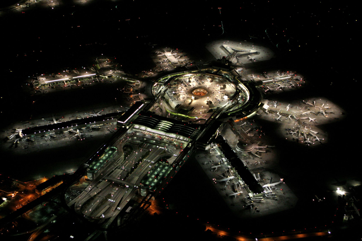 <a href="/content/San_Francisco_International_Airport" style="color:blue">San Francisco International Airport</a> at night, with departure gates radiating out from the <a href="/content/Airport_terminal" style="color:blue">terminal building</a>, <a href="/content/Aerobridge" style="color:blue">aerobridges</a>, <a href="/content/Airport_apron" style="color:blue">apron</a>, and parked planes