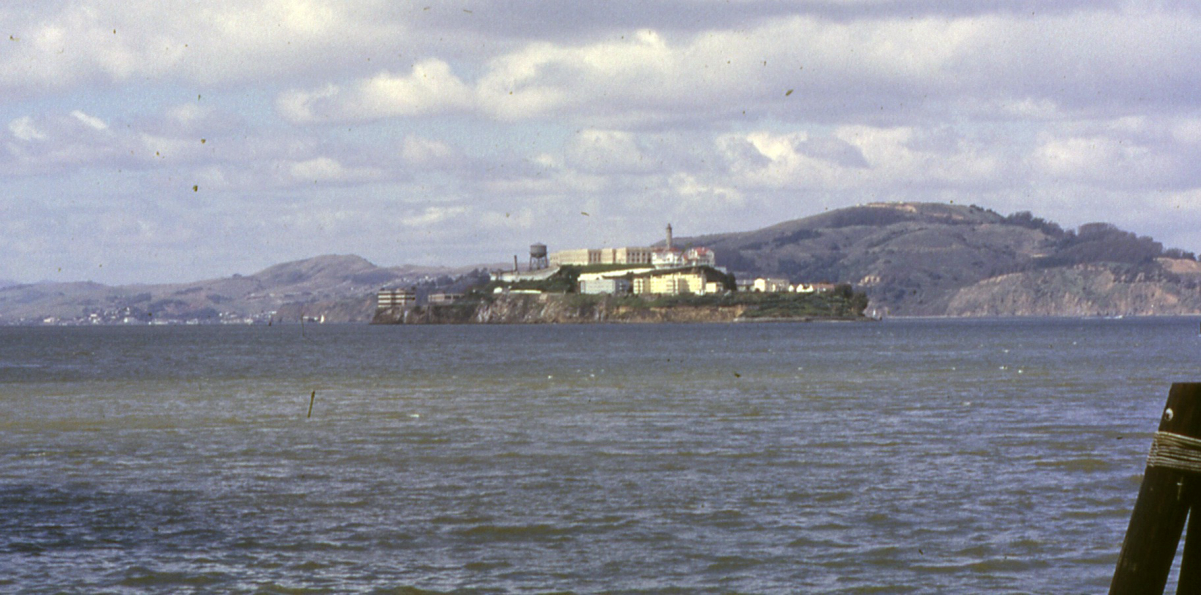 Alcatraz, with <a href="/content/Angel_Island_(California)" style="color:blue">Angel Island</a> (the fugitives' intended destination) in background, <a href="/content/San_Francisco_Bay" style="color:blue">San Francisco Bay</a>, March 1962