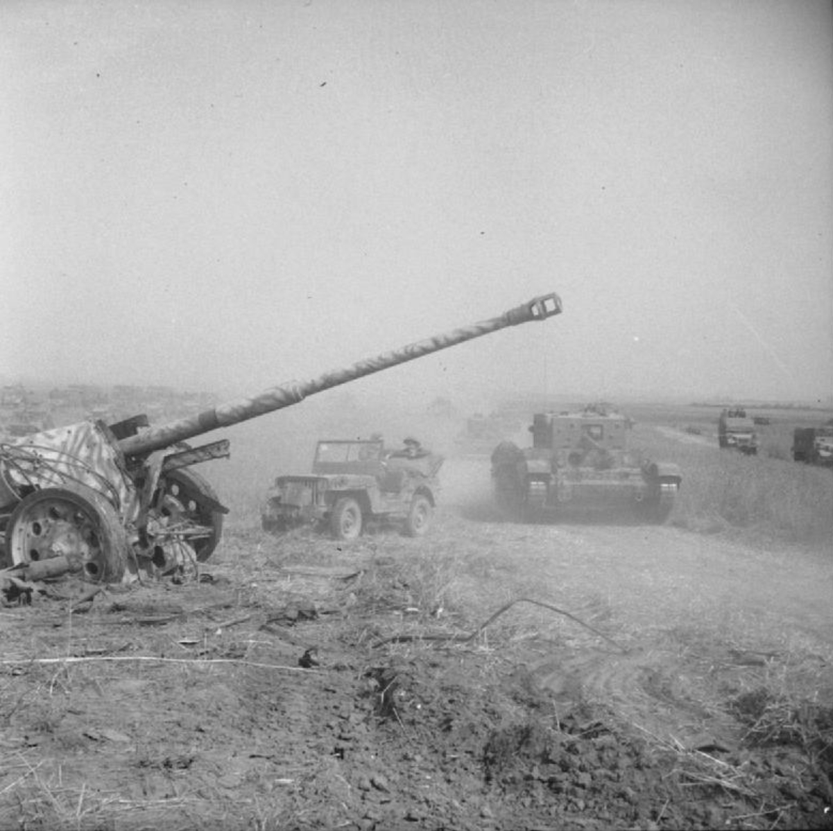 A <a href="/content/Cromwell_tank" style="color:blue">Cromwell tank</a> and <a href="/content/Willys_MB" style="color:blue">jeep</a> pass an abandoned German <a href="/content/8.8_cm_PaK_43" style="color:blue">88 mm</a> anti-tank gun during Operation Totalize, 8 August 1944.