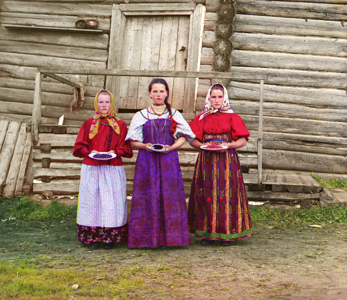 Young women offer berries to visitors to their <a href="/content/Izba" style="color:blue">izba</a> home, 1909. Those who had been <a href="/content/Serfs" style="color:blue">serfs</a> among the Russian peasantry were officially <a href="/content/Emancipation_reform_of_1861" style="color:blue">emancipated</a> in 1861. Photograph by <a href="/content/Sergey_Prokudin-Gorsky" style="color:blue">Sergey Prokudin-Gorsky</a>.