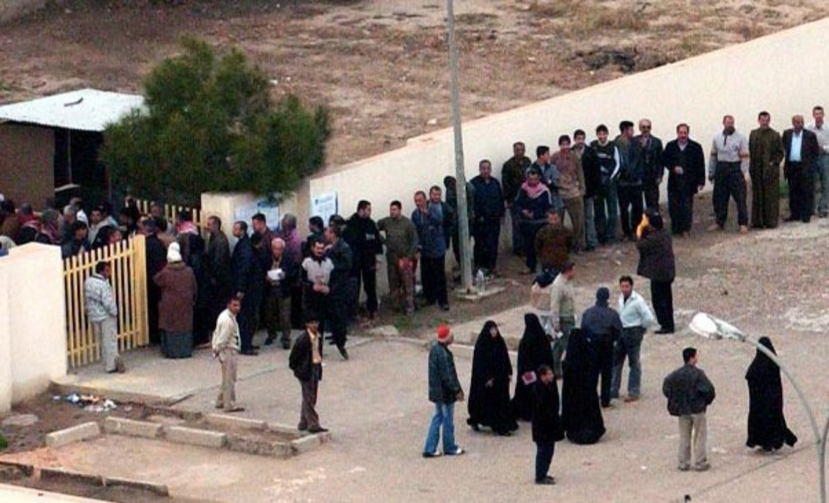 Voters lining up outside a <a href="/content/Baghdad" style="color:blue">Baghdad</a> polling station during the <a href="/content/January_2005_Iraqi_legislative_election" style="color:blue">2005 Iraqi election</a>. Voter turnout was considered high despite widespread concerns of violence.