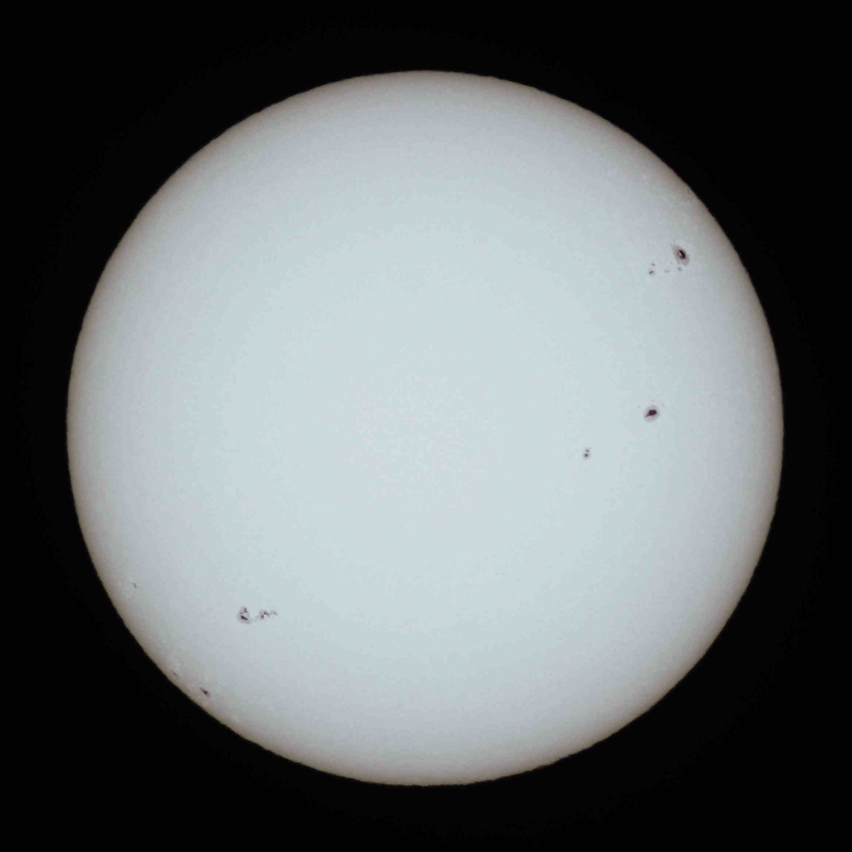 Sun with <a href="/content/Sunspot" style="color:blue">sunspots</a> and <a href="/content/Limb_darkening" style="color:blue">limb darkening</a> as seen in <a href="/content/Visible_light" style="color:blue">visible light</a> with <a href="/content/Solar_filter" style="color:blue">solar filter</a>.