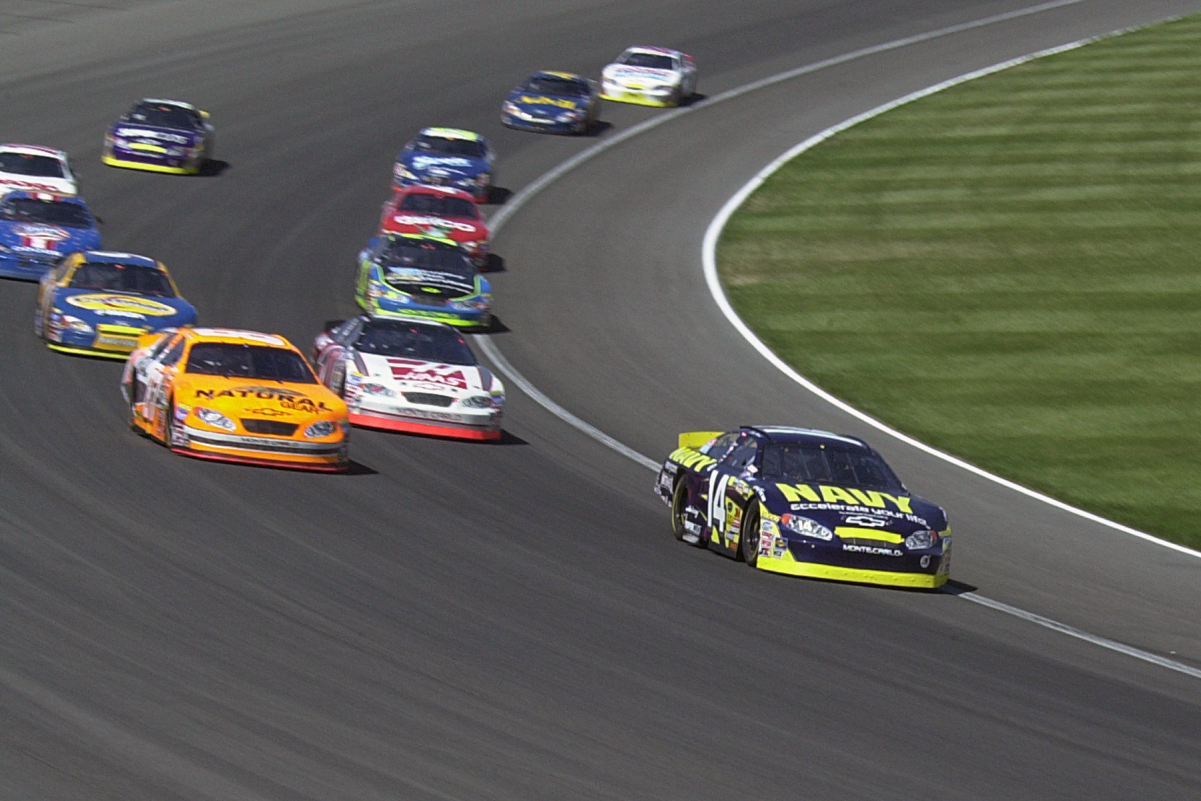 As a change of direction occurs while the racing cars turn on the curved track, their velocity is not constant.